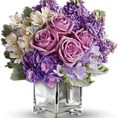 Visions of sugar plum fairies dance to life with this magical bouquet. Lush lavenders, frosty whites and silvery greens look romantic and refreshing inside a cool cube vase.
Robust roses, delicate hydrangea and feminine stock make a cool collection inside an icy, clear glass cube vase.