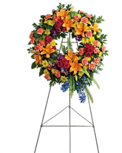 <div id="mark-1" class="m-pdp-tabs-marketing-description">Like a beacon of love and hope, this glorious wreath of hydrangea, roses and lilies echoes the joy of your precious memories.</div>
<div id="desc-1">
<ul>
 	<li>This wreath features green hydrangea, hot pink spray roses, orange asiatic lilies, orange carnations, blue delphinium, purple stock, yellow cushion spray chrysanthemums, huckleberry, variegated pittosporum, sword fern, silver dollar eucalyptus, and lemon leaf.</li>
 	<li>Delivered on a wire easel.</li>
</ul>
</div>