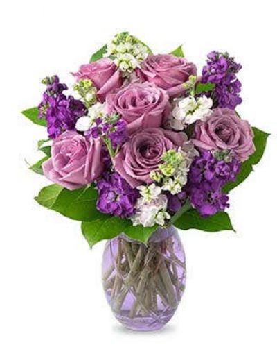 Lovely lavender roses, lavender stock, and pink stock are accented with a variety of lush greens in this amazing floral arrangement. Presented in a glass vase, the bouquet is a wonderful gift to help celebrate an anniversary, a birthday, or just because.