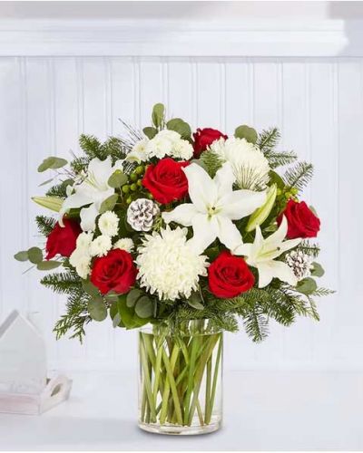 We’ve taken one of our best-selling bouquet designs and filled it with all the joyful colors and textures of the holiday season. An abundant, garden-inspired mix of blooms is gathered with glittery natural accents inside a clear glass vase. It’s a gift guaranteed to make a grand impression at every gathering.
<ul>
<li>All-around arrangement with red roses, white Oriental lilies, football mums and button poms, green hypericum; accented with silver dollar eucalyptus, assorted Christmas greens and glittered pinecones</li>
<li>Artistically designed in a clear glass vase</li>
<li>Extra large arrangement measures approximately 33"H x 20"W</li>
<li>Large arrangement measures approximately 31"H x 19"W</li>
<li>Medium arrangement measures approximately 28"H x 19"W</li>
<li>Small arrangement measures approximately 27H x 18"W</li>
<li>Our florists hand-design each arrangement, so colors, varieties and container may vary due to local availability</li>
<li>To ensure lasting beauty, Oriental lilies may arrive in bud form and will fully bloom over the next few days</li>
</ul>